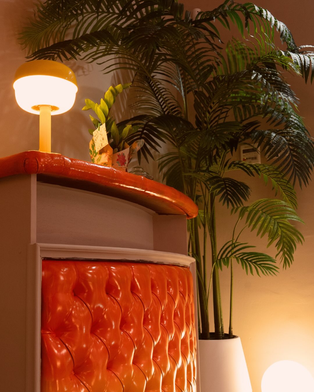 Recepción del estudio Cardo Tattoo Granada con mostrador tapizado y plantas
